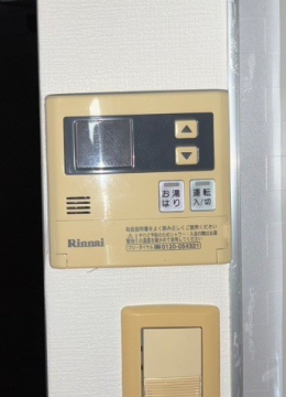 台所に設置された交換前の古い給湯器リモコン